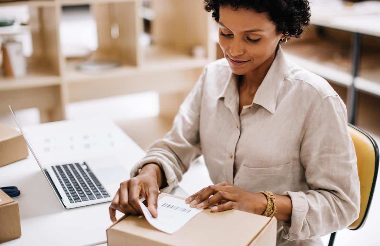 Woman confidently labeling and shipping e-commerce packages during peak season rush