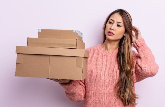 E-commerce owner with shipping problems holding parcels